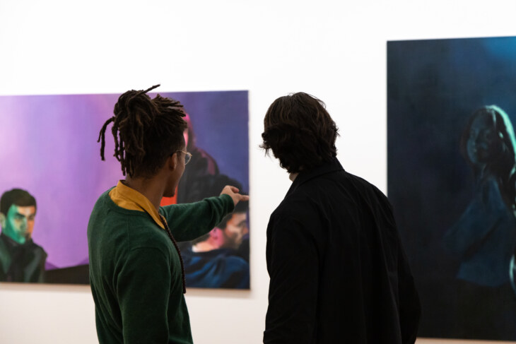 Zwei junge Menschen in der Daueraustellung Kunst unterhalten sich vor einem Gemälde der Gegenwartskunst