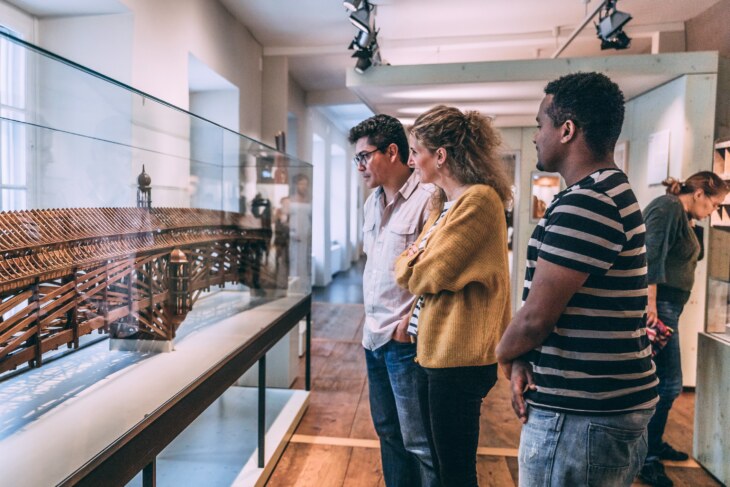 Eine Gruppe Menschen schaut sich das Modell des Moser Damms in der Abteilung der Kulturgeschichte im Museum zu Allerheiligen an.