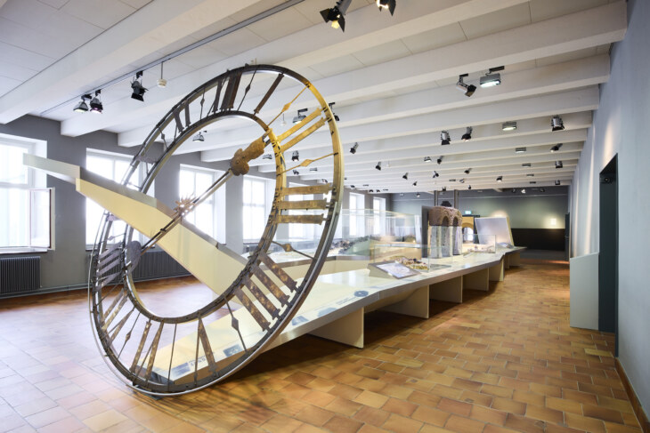 Blick in den Ausstellungsraum, der einen Überblick über die Kulturgeschichte von Schaffhausen gibt. Vorne ist das Ziffernblatt einer grossen Turmuhr aufgestellt.