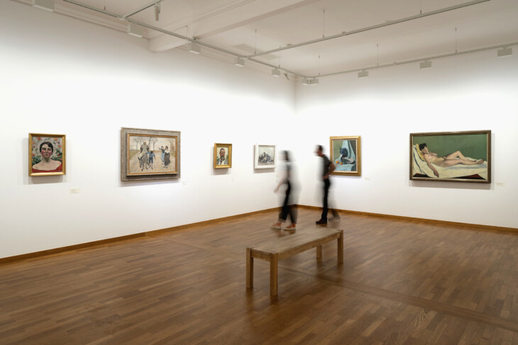 Blick in die moderne Kunstabteilung. Gemälde von Hodler und Vallonton sind zu sehen. Im Raum bewegen sich zwei Personen.