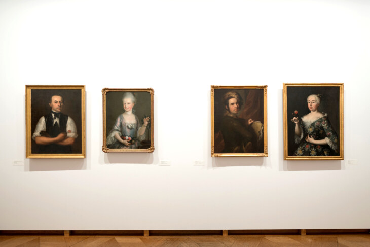 An einer weissen Wand hängen vier Portraits im Barock-Stil.