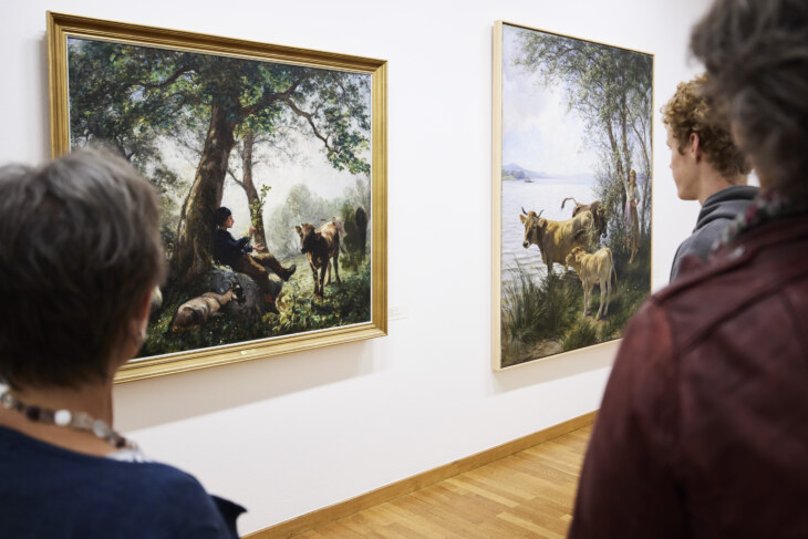Gemälde von Rudolf Koller. Drei Personen betrachtet dieses Gemälde. Sie stehen mit dem Rücken zur Kamera.