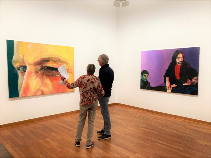 Zwei Personen diskutieren vor einem Kunst-Gemälde